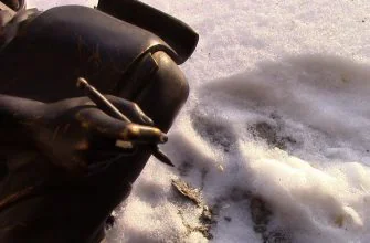 Рука с пишущим инструментом медной статуи "Хрисипп" на фоне снега